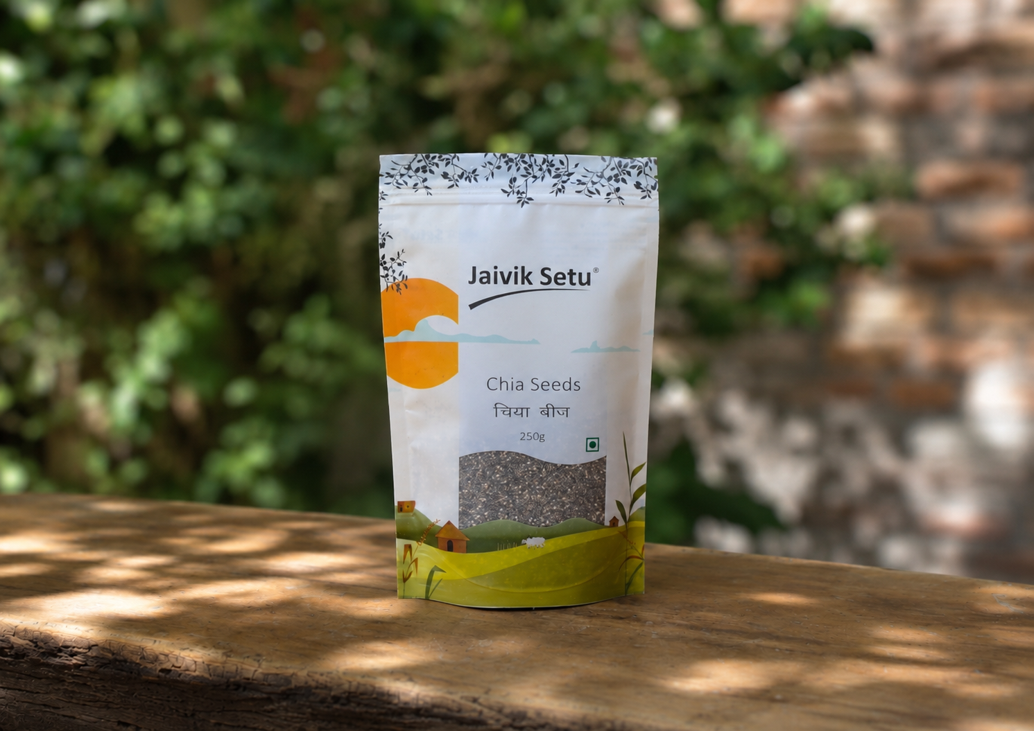 A stand-up pouch of Jaivik Setu Chia Seeds placed on a wooden surface with a blurred outdoor background of green foliage and a brick wall.